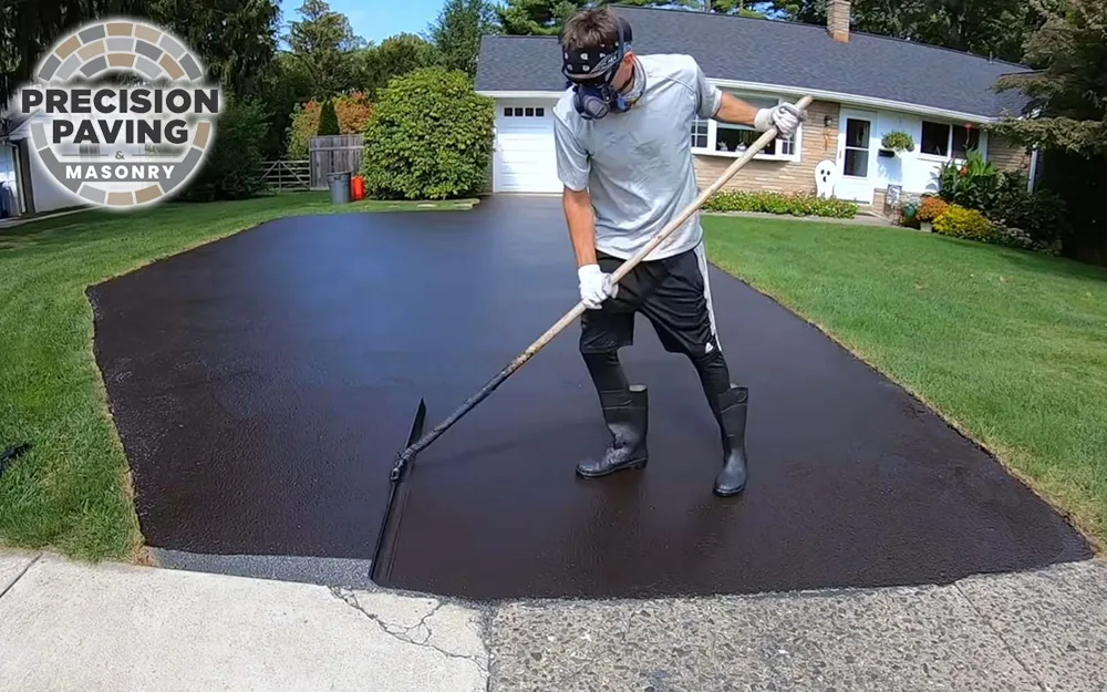 man working on applying driveway sealcoating