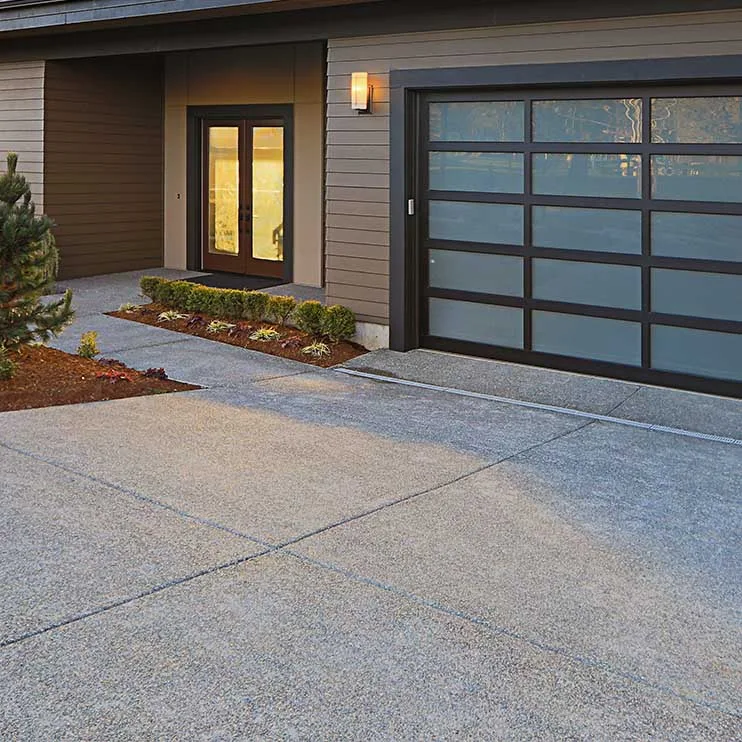 new-driveway-installation Side-by-side comparison of a driveway before and after sealcoating. The 'before' image displays signs of wear, including visible cracks, faded color, and a rough texture. In the 'after' image, the driveway appears refreshed, with a smooth, dark surface, showcasing the positive impact of sealcoating in enhancing the overall appearance and longevity of the driveway.